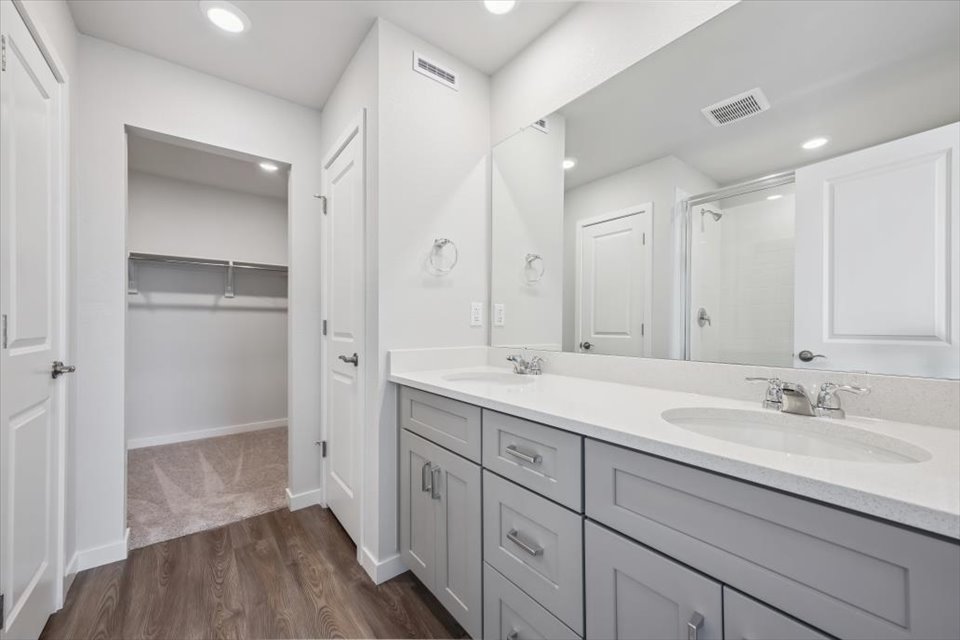 A bathroom with white cabinets.