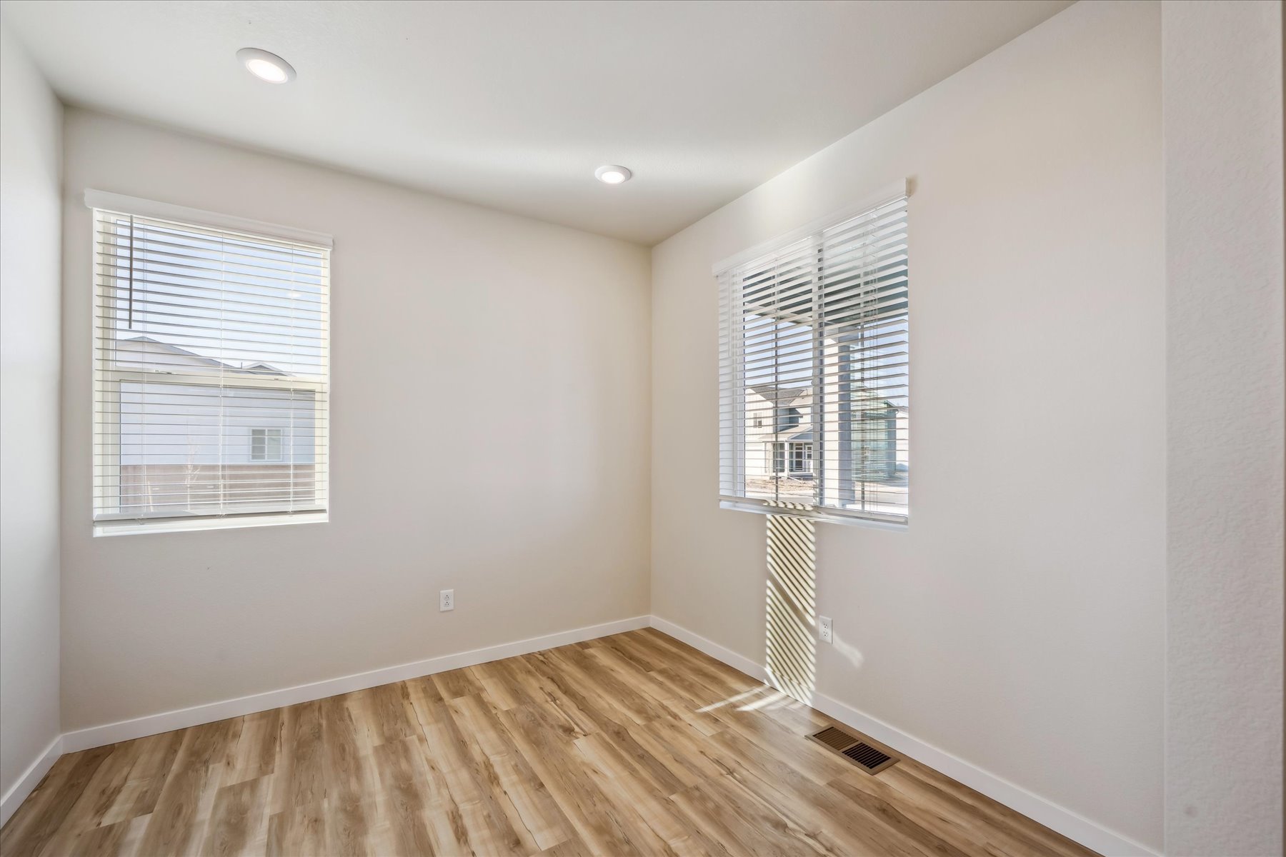 A room with a wood floor and windows.