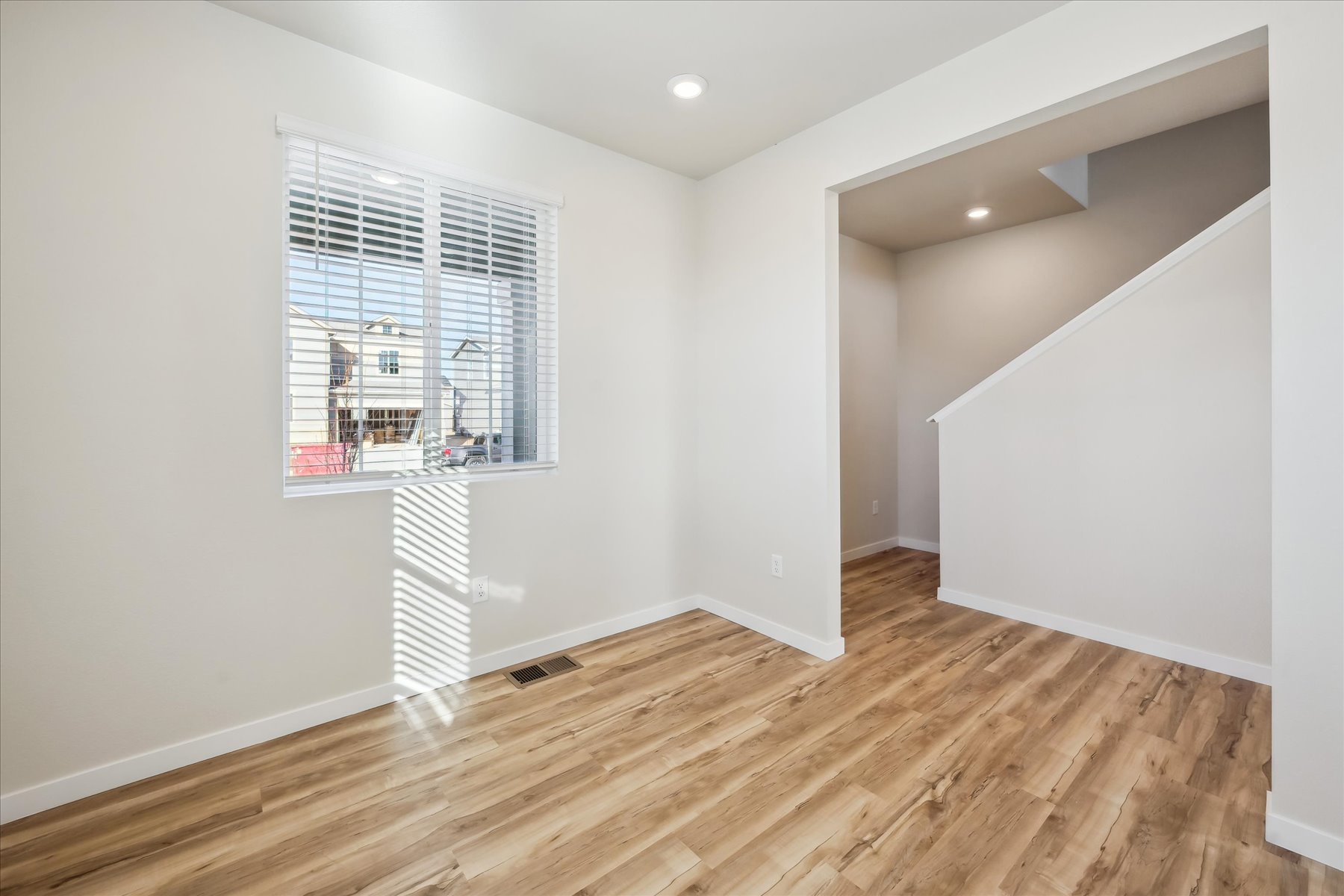 A room with a wood floor and a window.