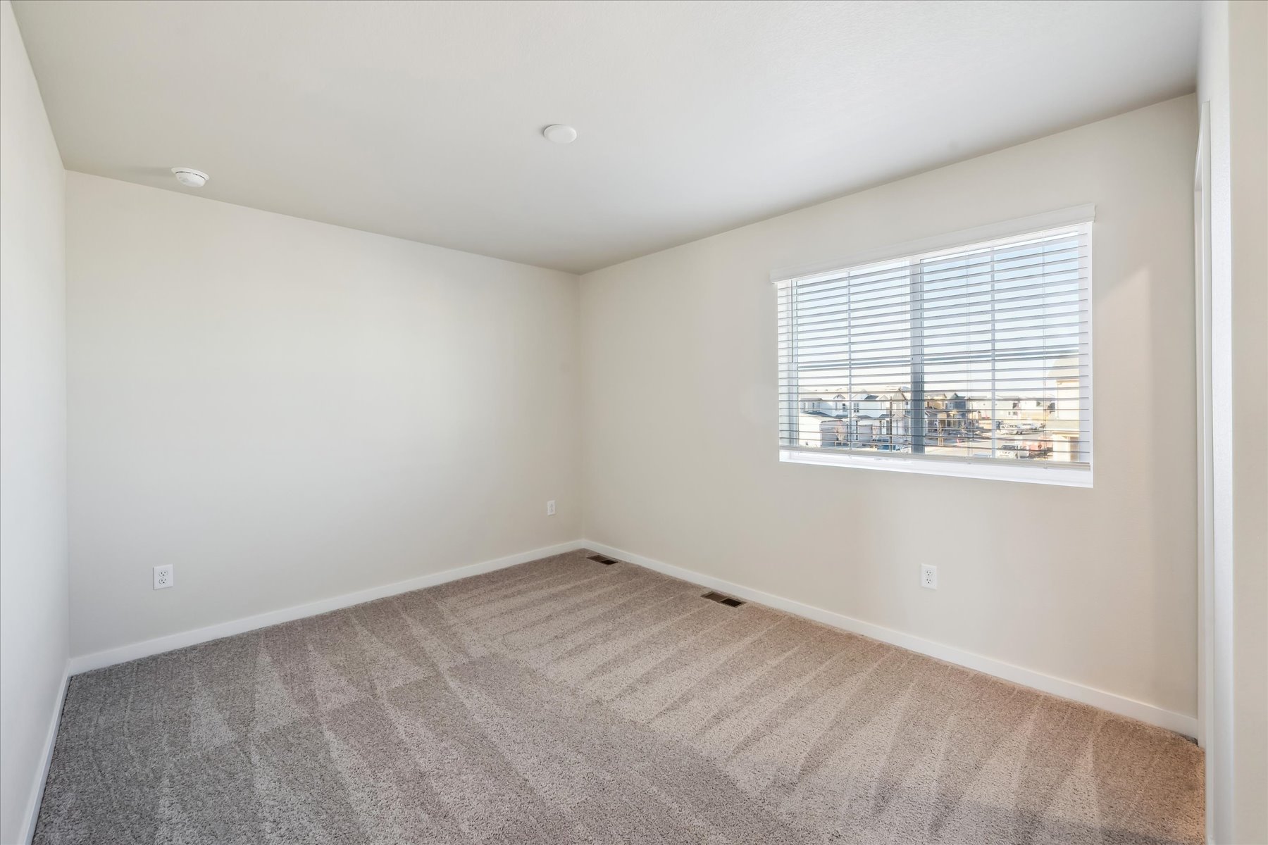A room with a window and a carpet.