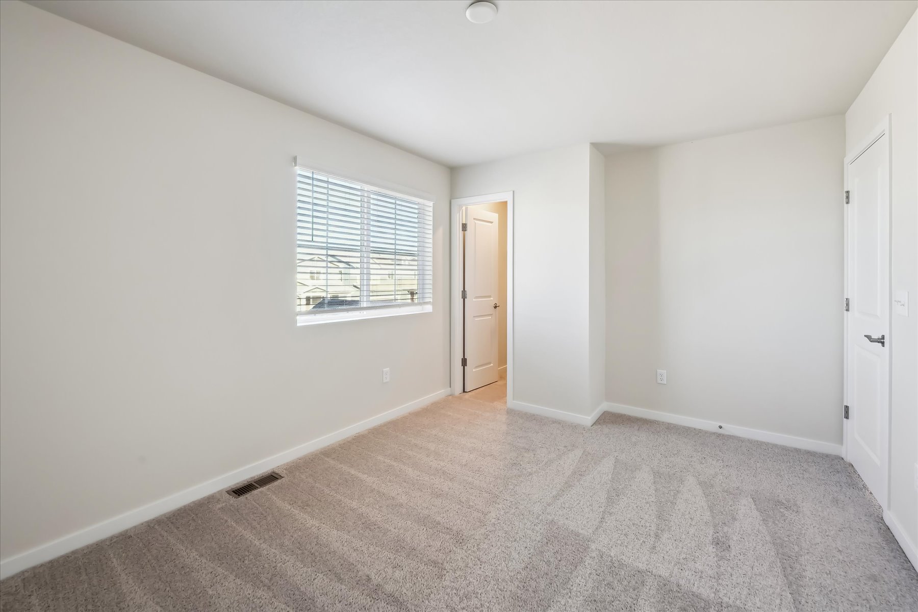 A room with a carpet and a window.