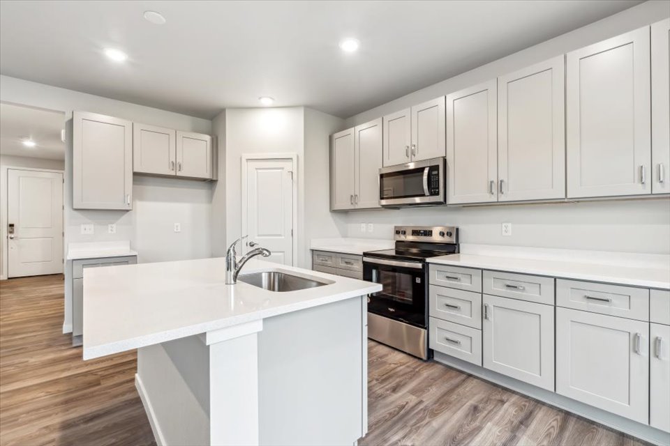 A kitchen with white cabinets.