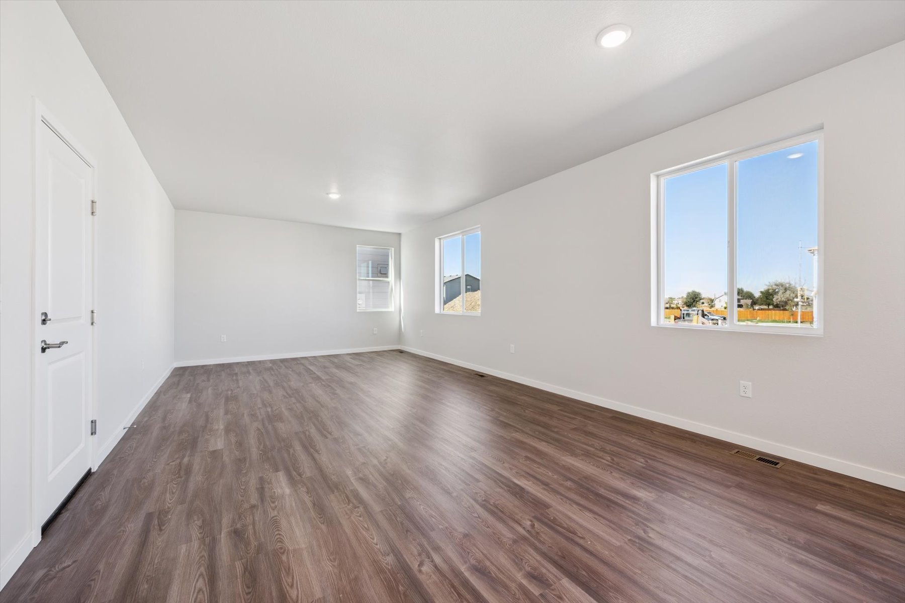 A room with a wood floor and windows.