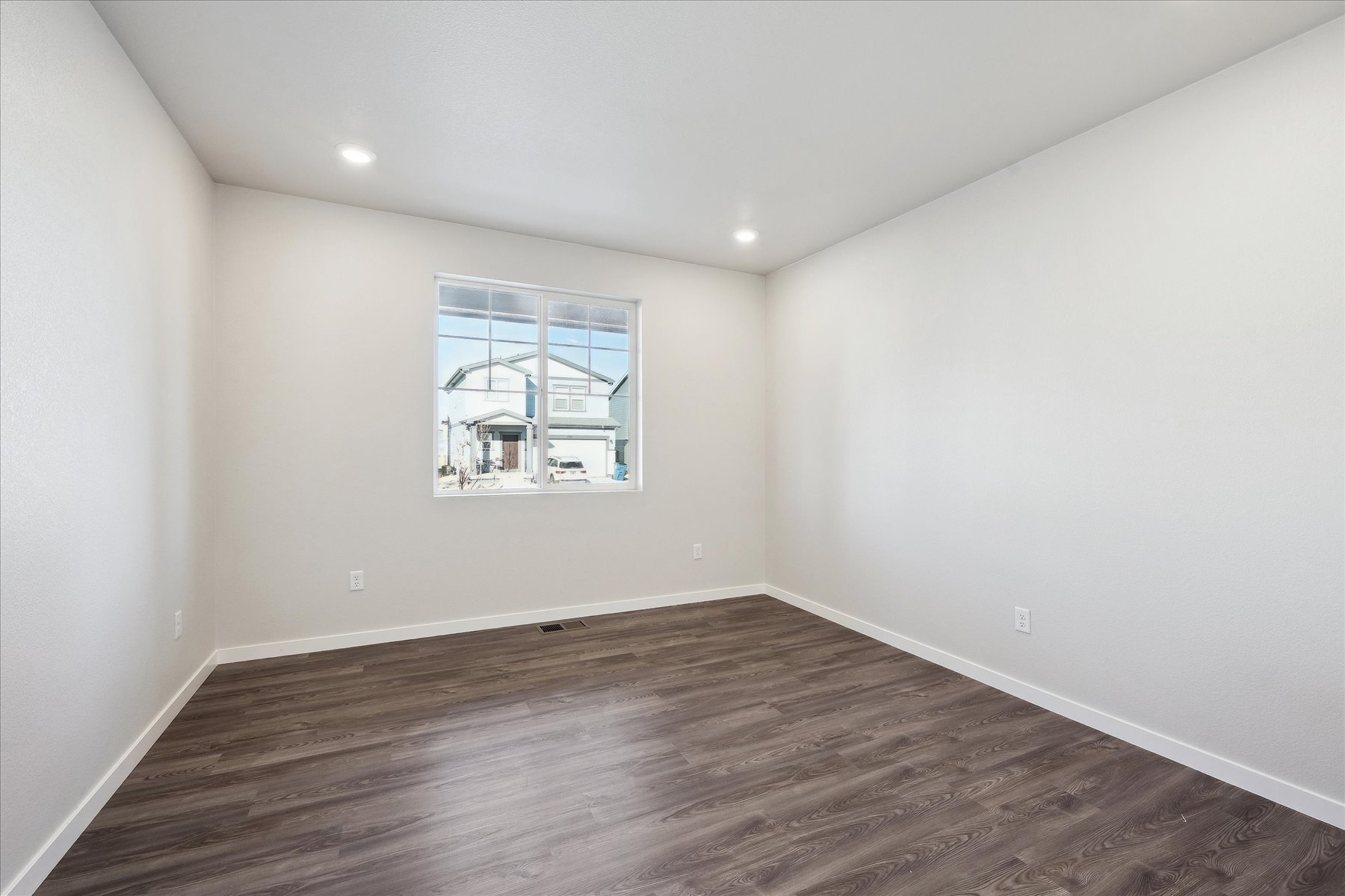 A room with a wood floor and a window.