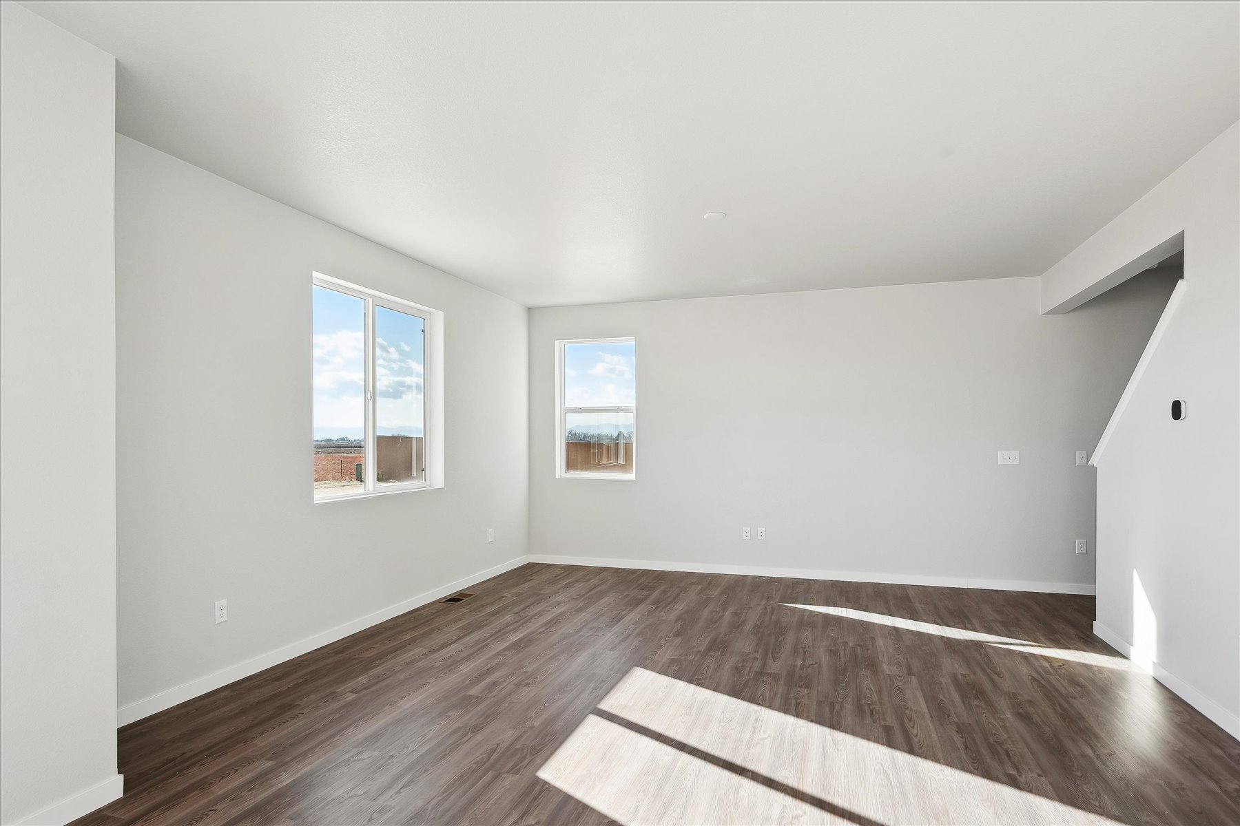 A room with a wood floor and a rug in it.