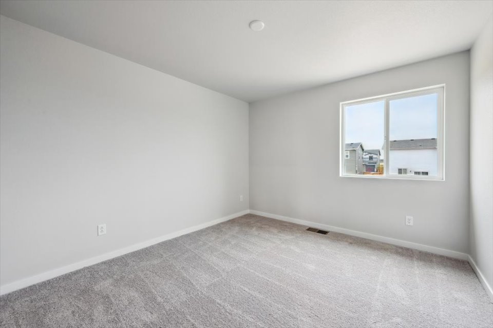 A room with a window and a carpet.
