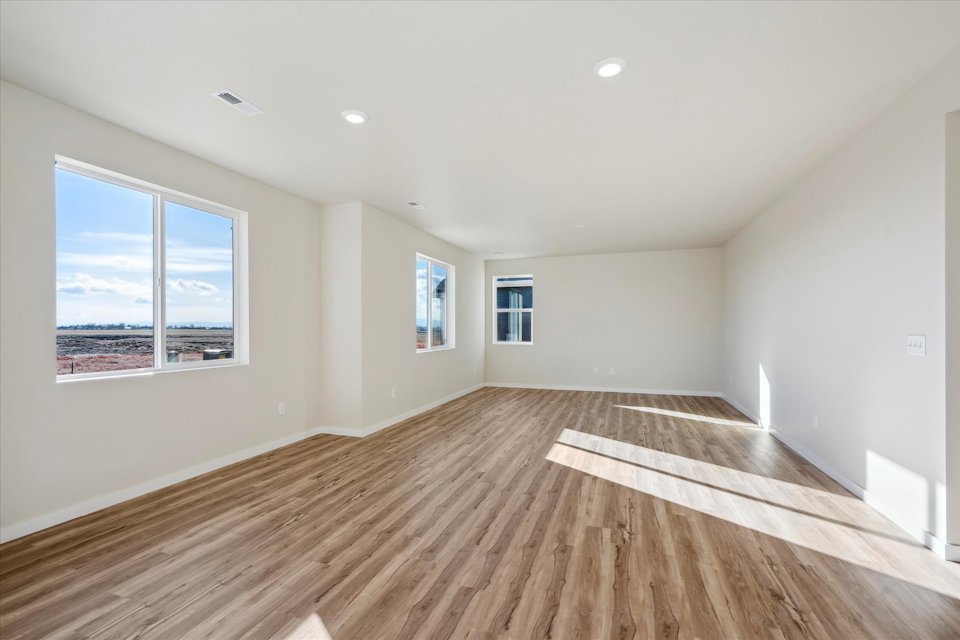 A room with a wood floor and a large window.