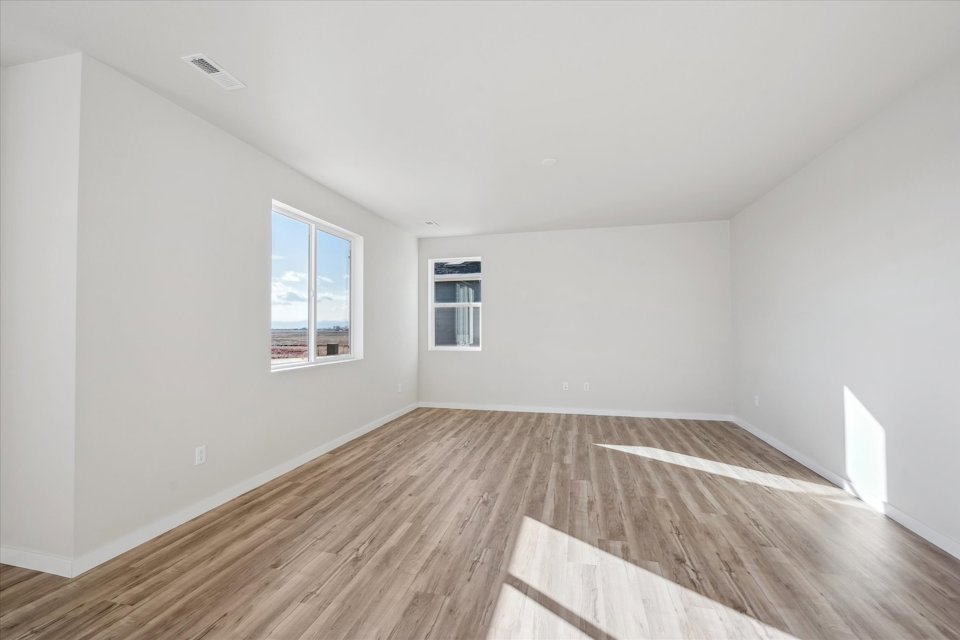 A room with windows and wood floors.