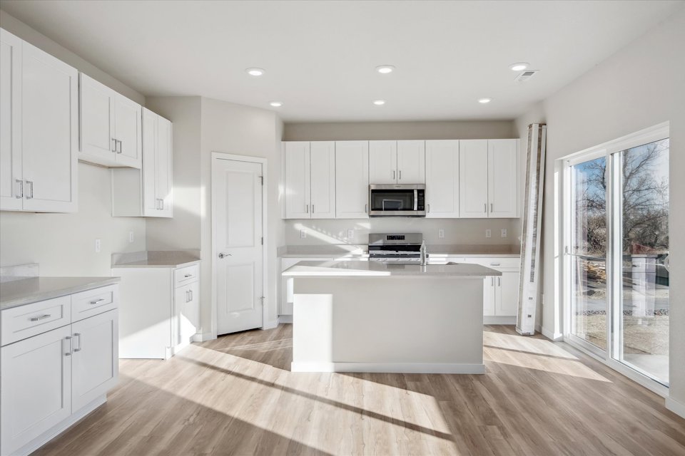 A kitchen with white cabinets.