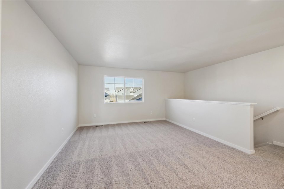 A room with a window and a white wall.