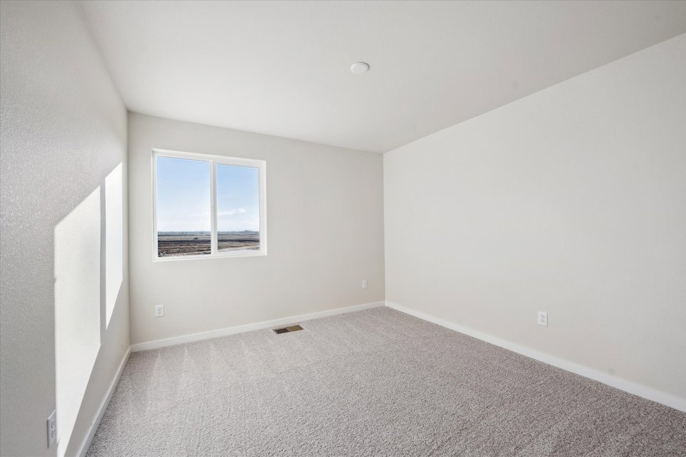 A room with a window and carpet.