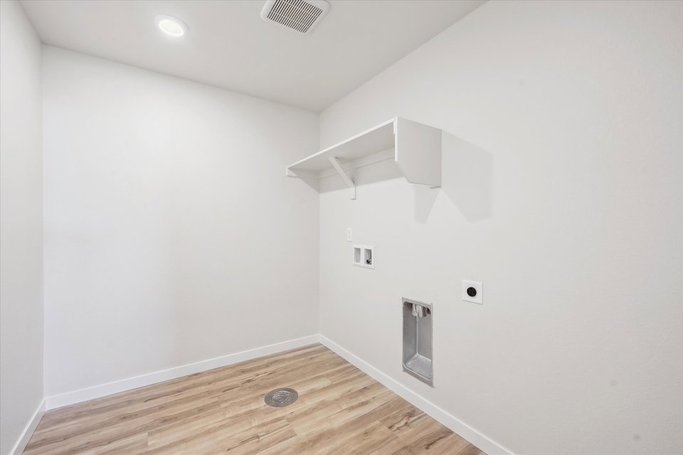 A room with a wood floor and white walls.