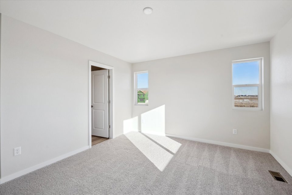 A room with a carpet and a door.