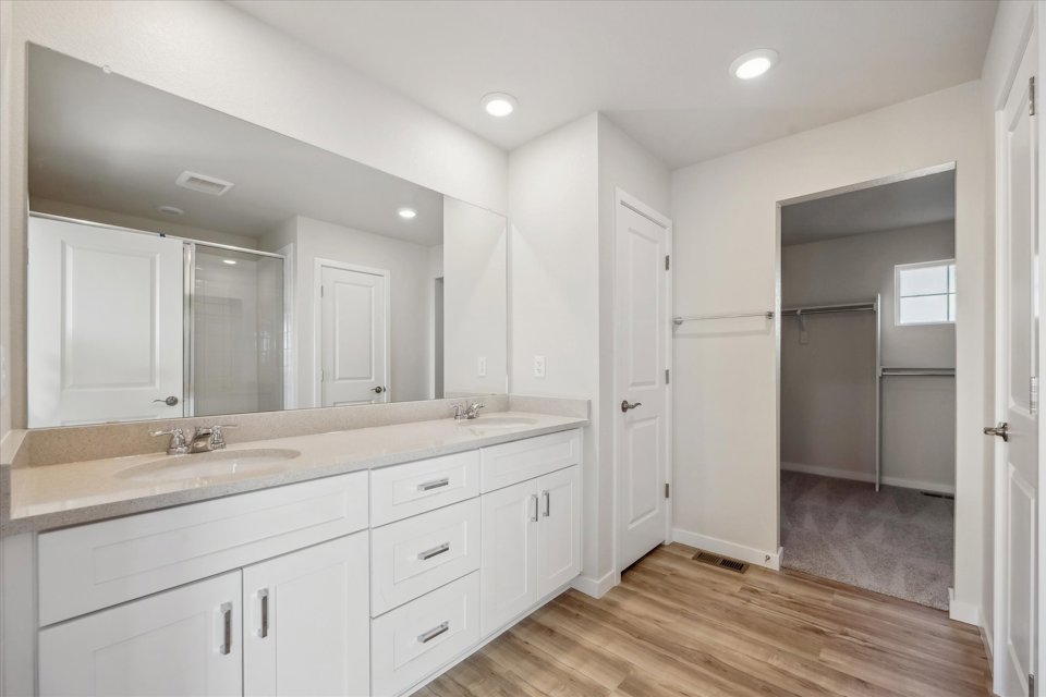 A bathroom with white cabinets.