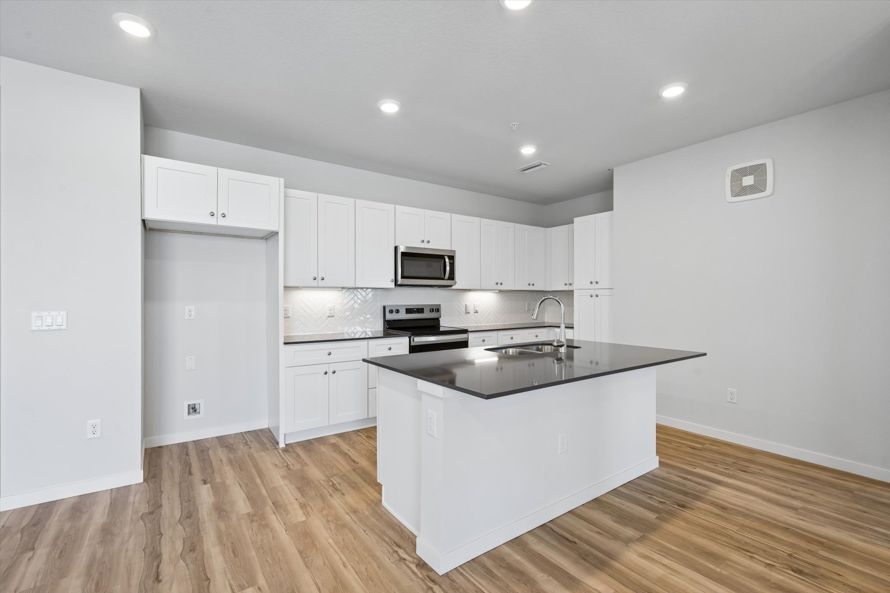 A kitchen with white cabinets.