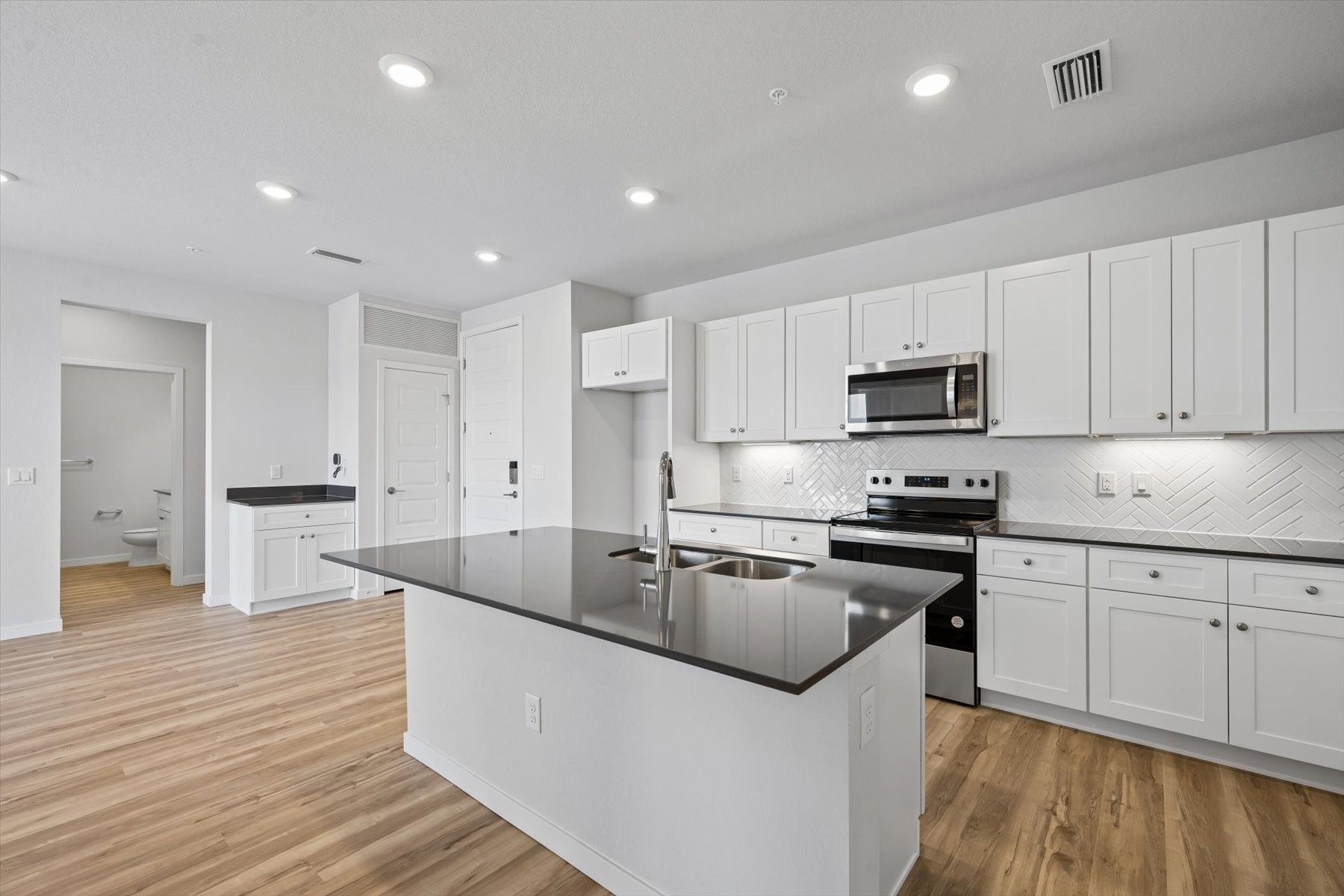 A kitchen with white cabinets.