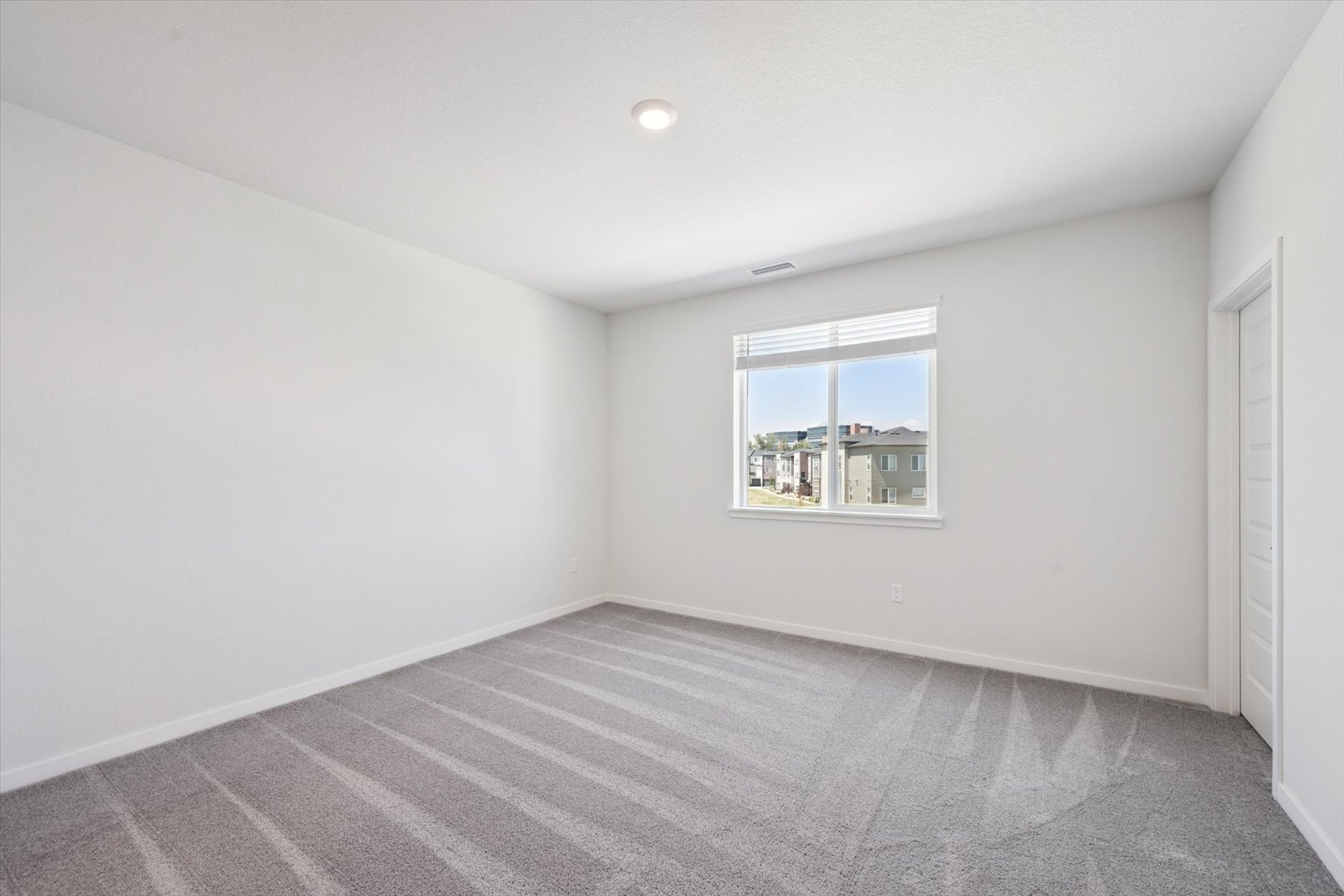 A room with a window and a rug.
