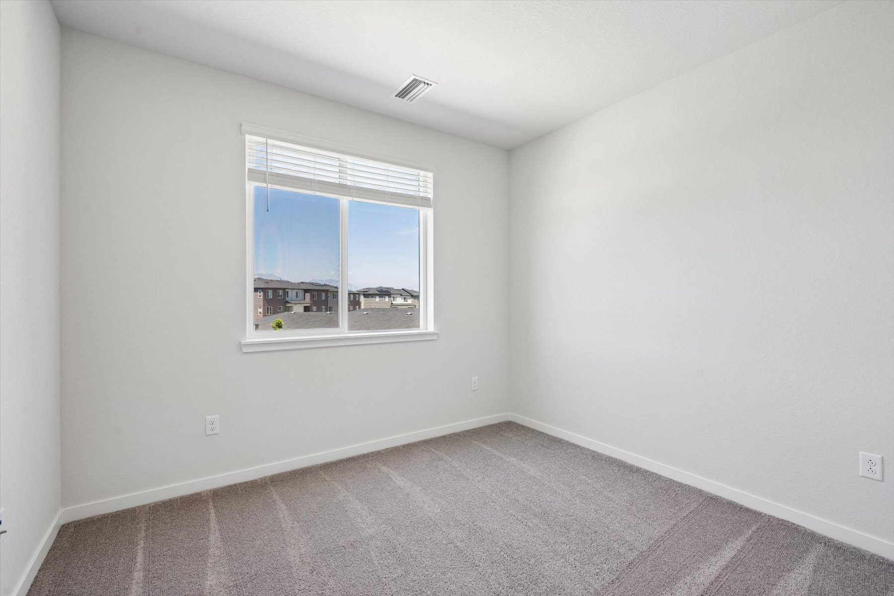 A room with a window and carpet.