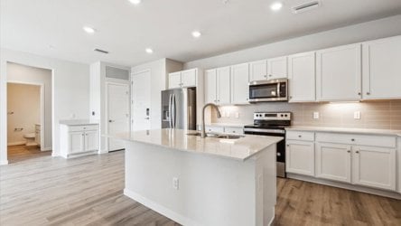 A kitchen with white cabinets.