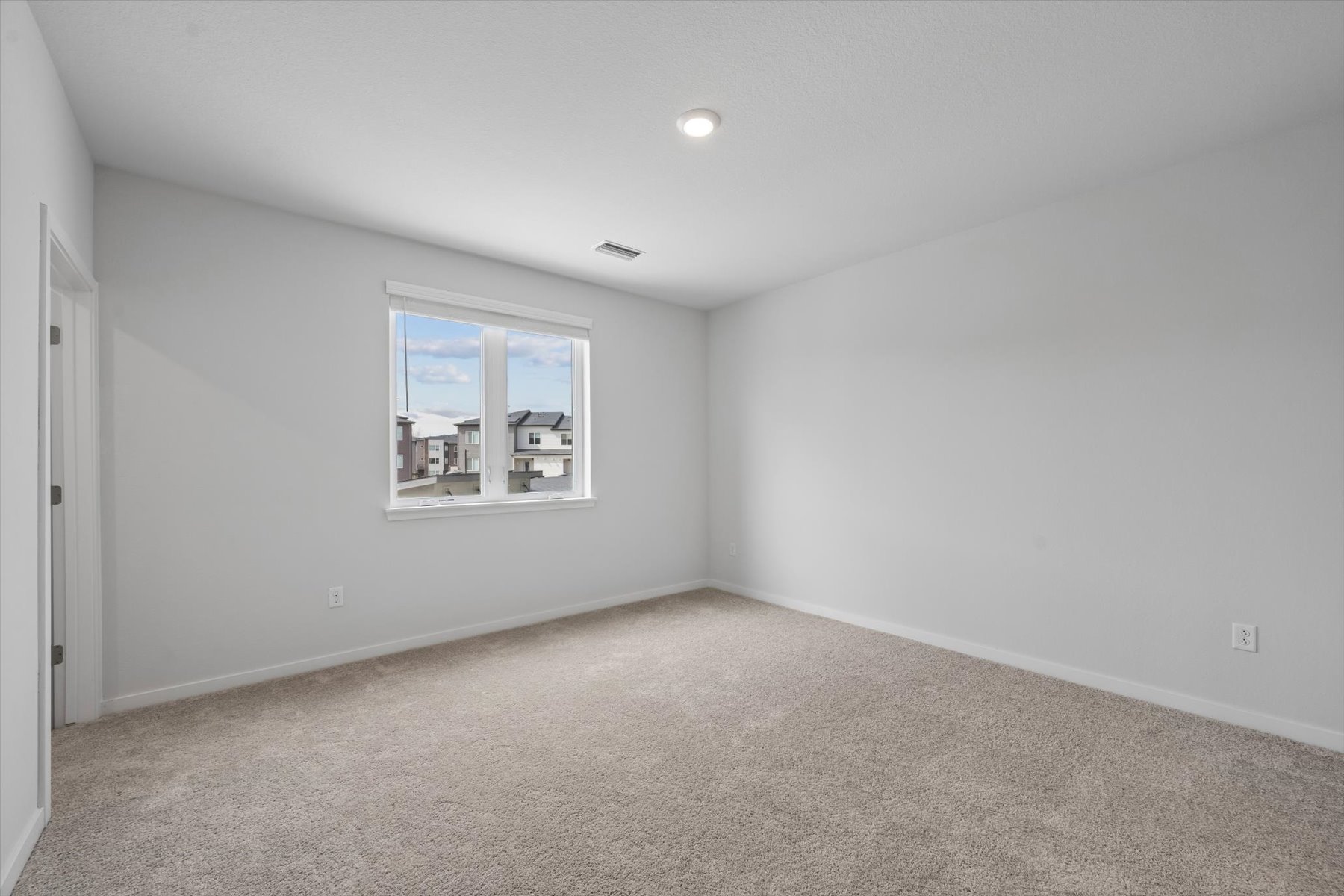 A room with a window and a carpet.