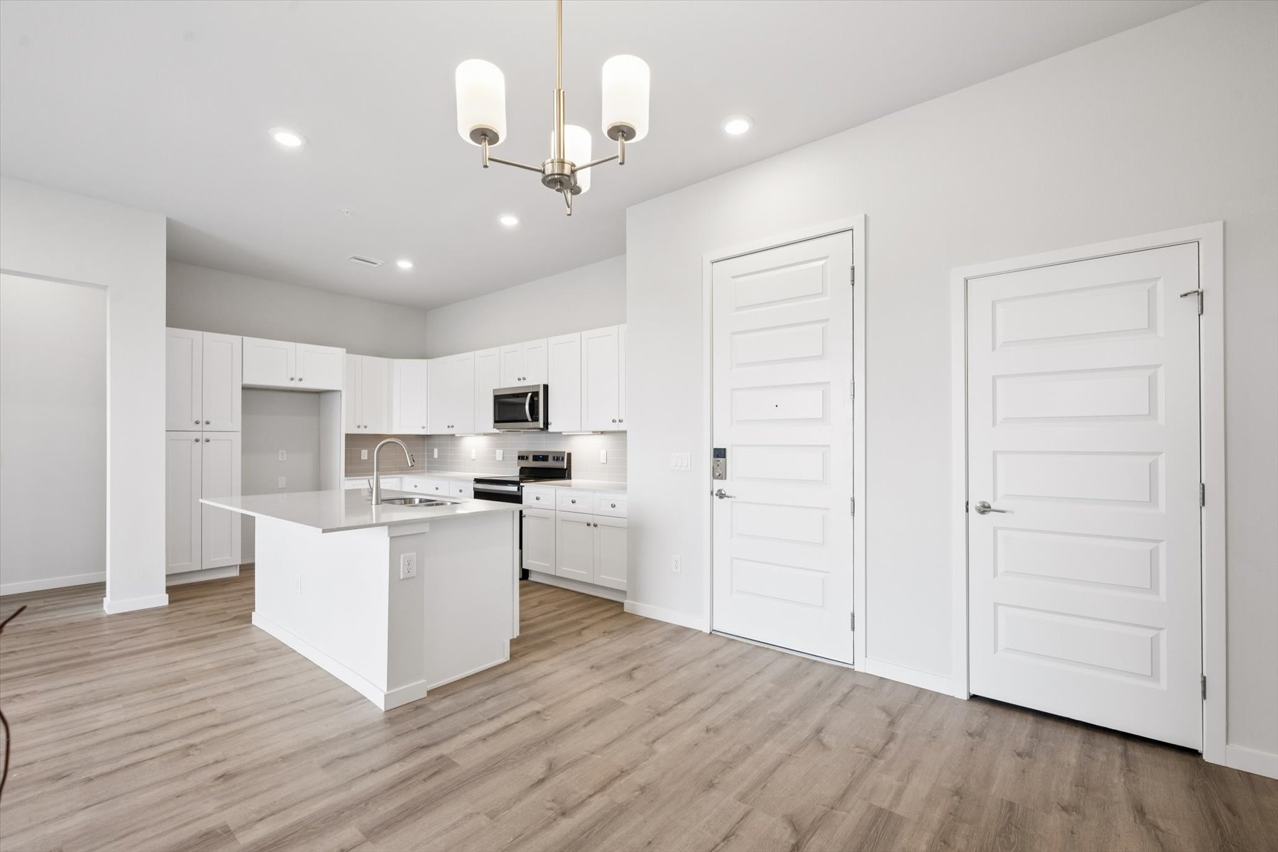 A kitchen with white cabinets.