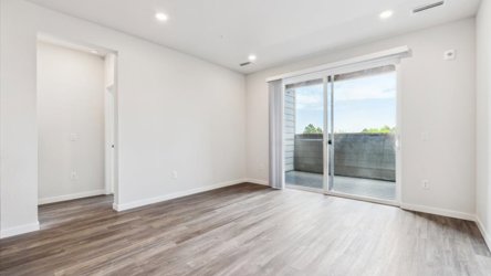 A room with a wood floor and a wood floor with a window.