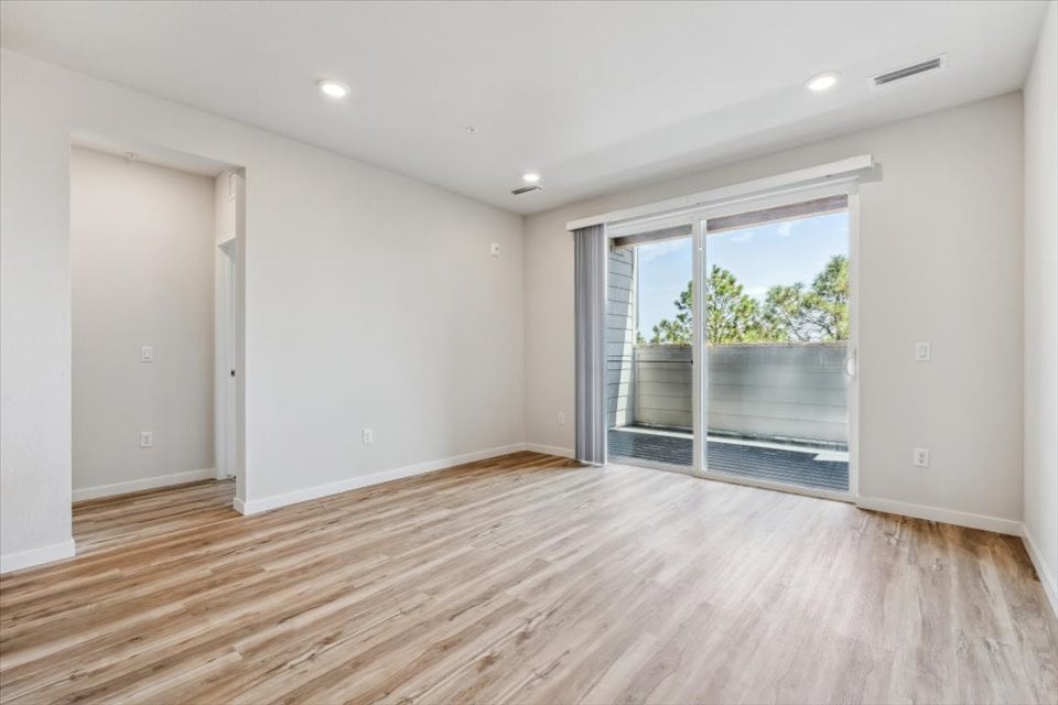 A room with a wood floor and a wood floor with a window.