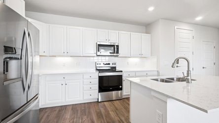 A kitchen with white cabinets.