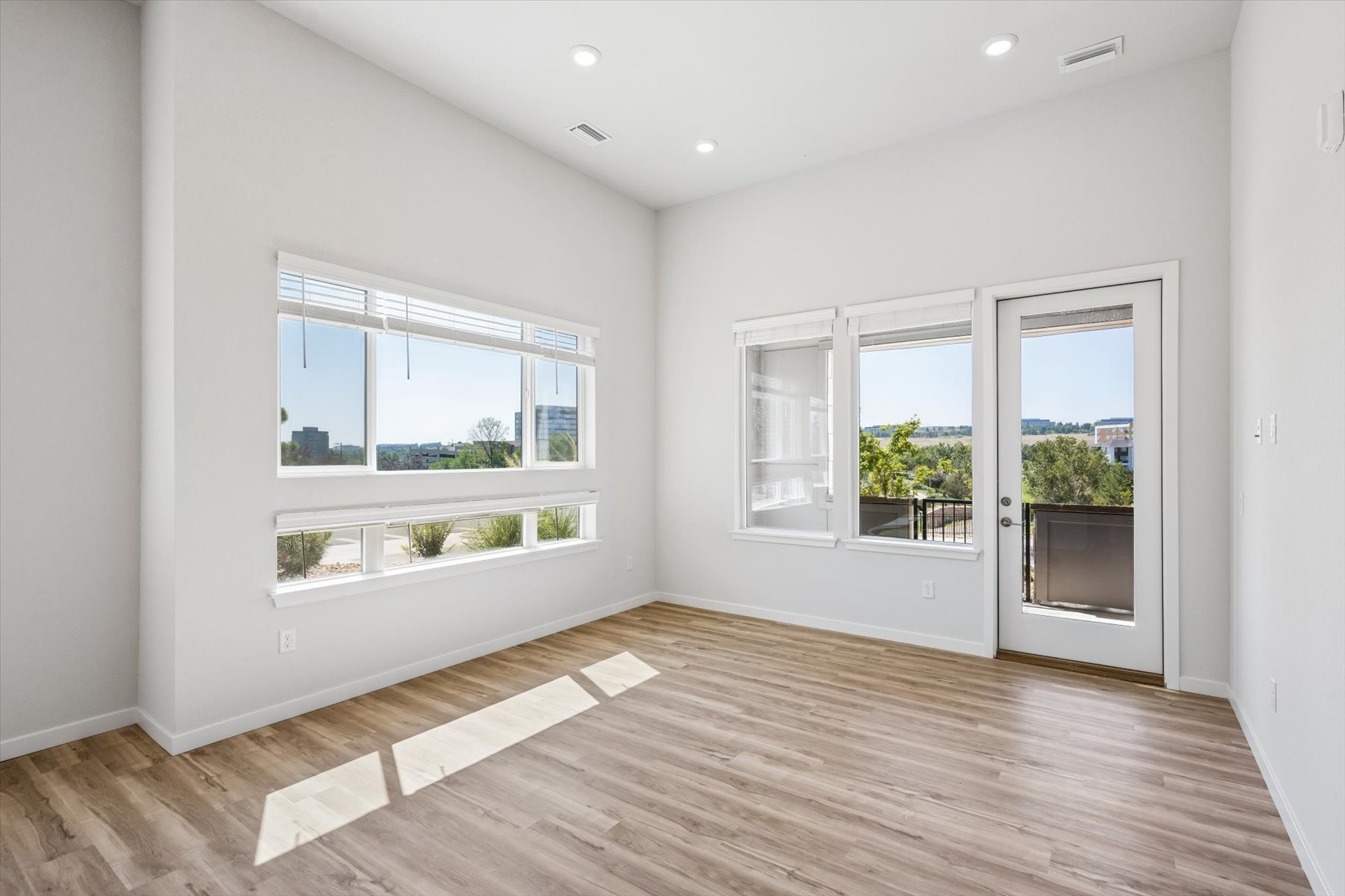 A room with a wood floor and windows.