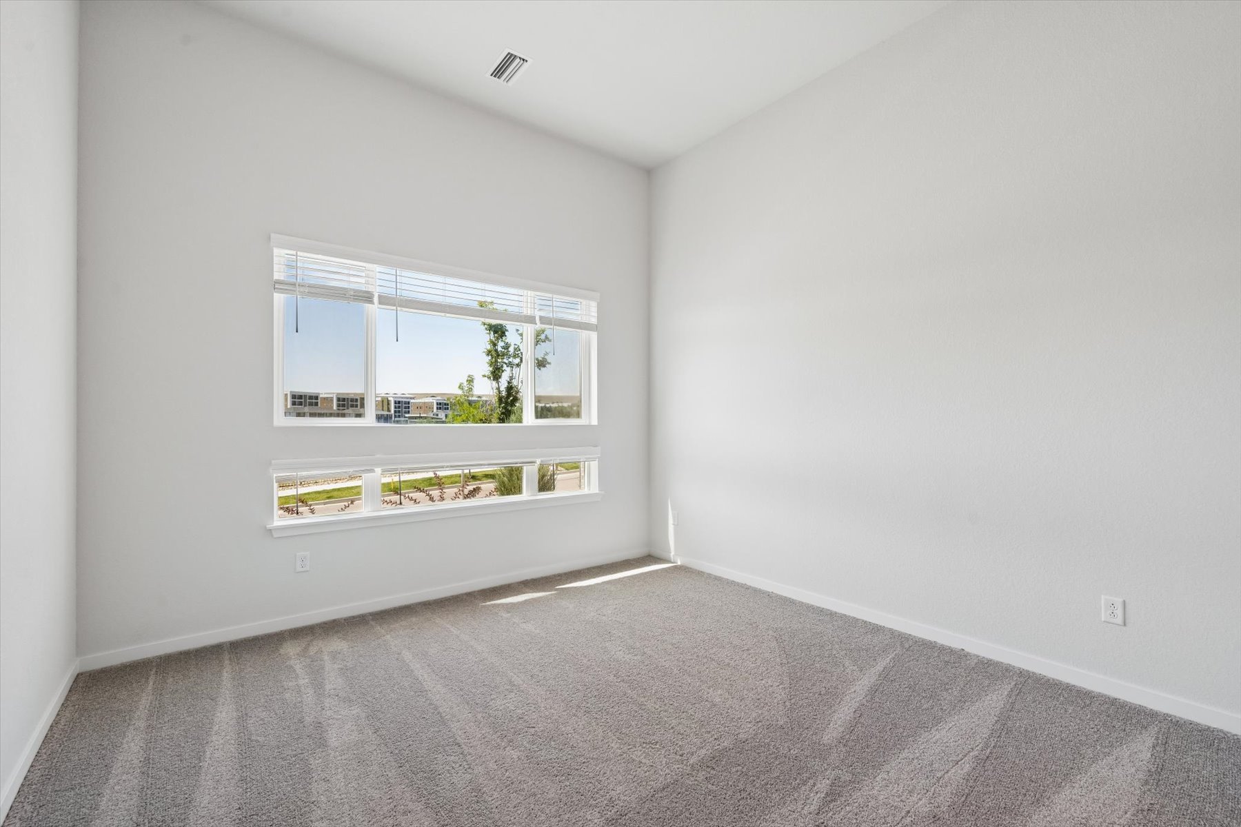 A room with a window and a carpet.