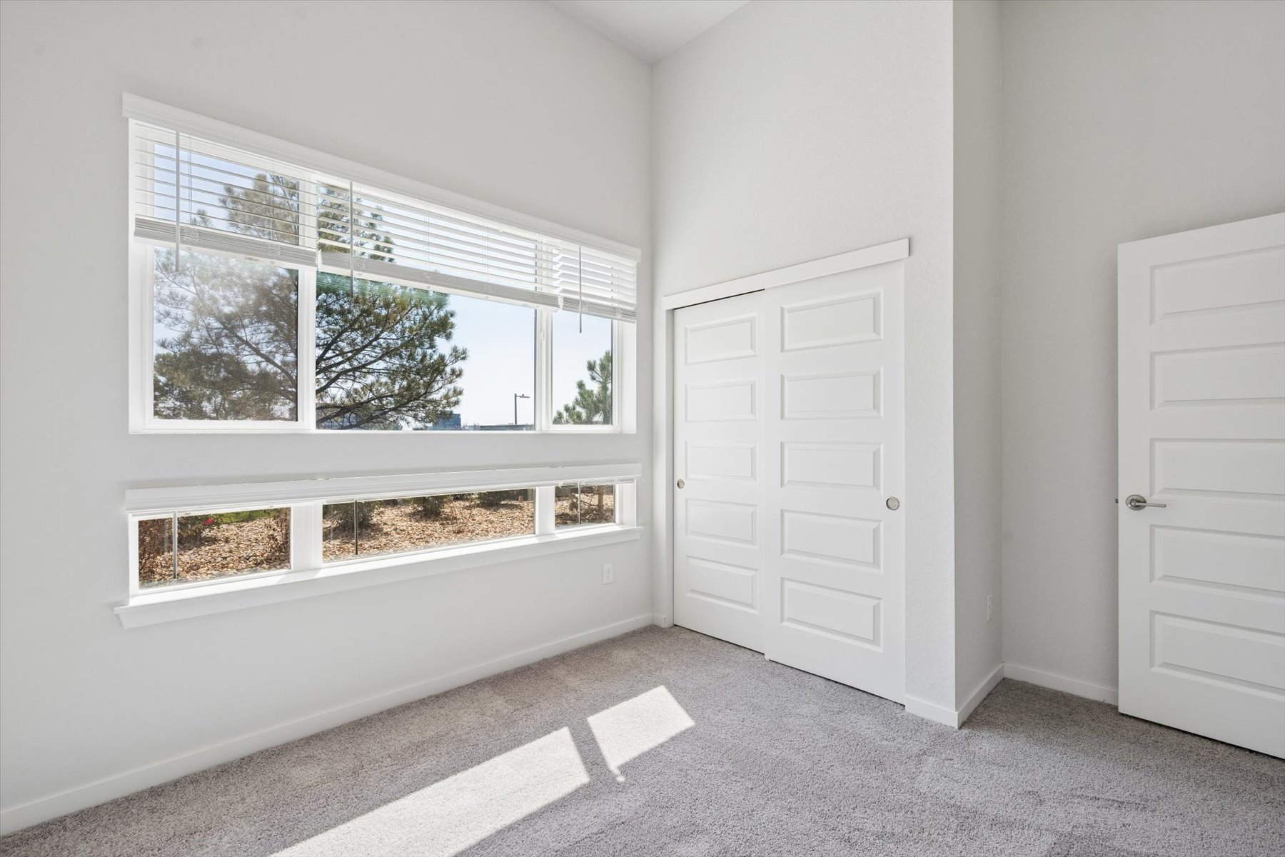 A room with white doors and a window.