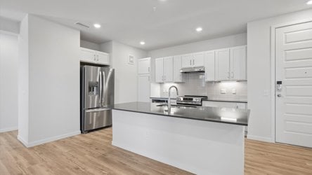 A kitchen with white cabinets.