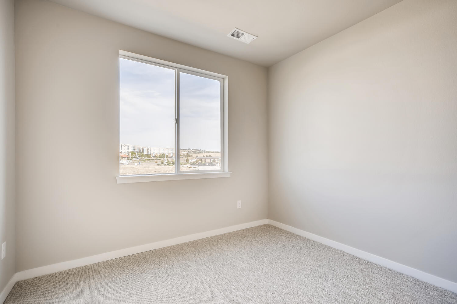 A room with a window and a carpet.