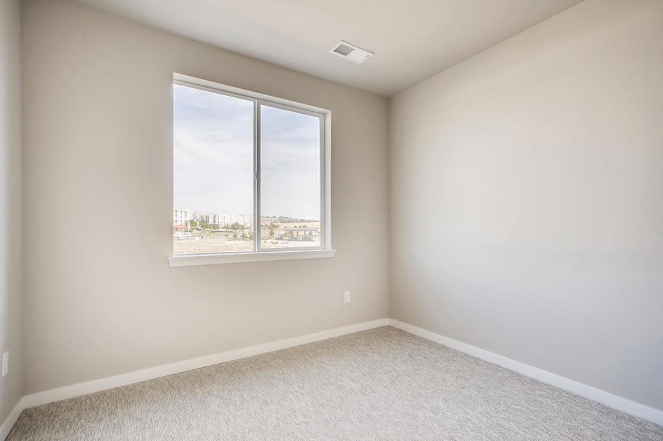 A room with a window and a carpet.