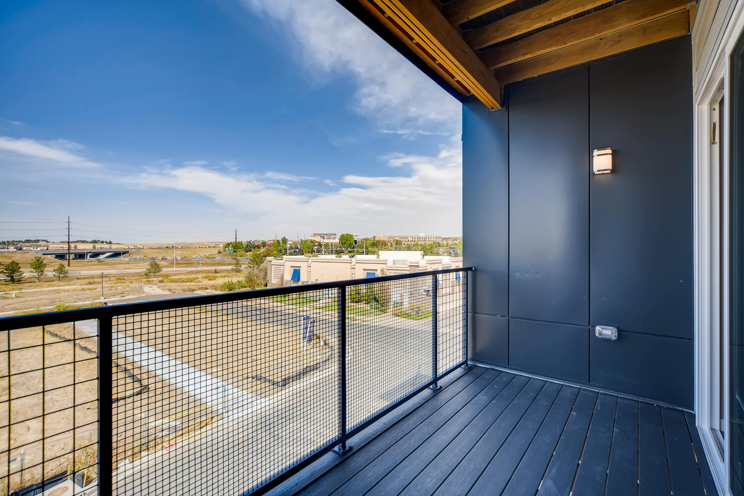 A deck with a railing and a field in the background.
