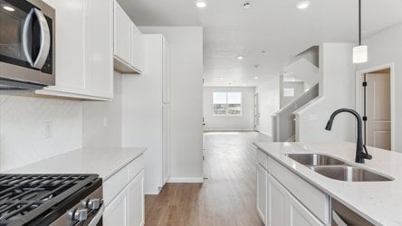 A kitchen with white cabinets.