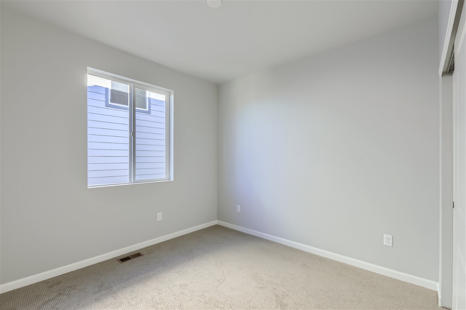A room with a window and a carpet.