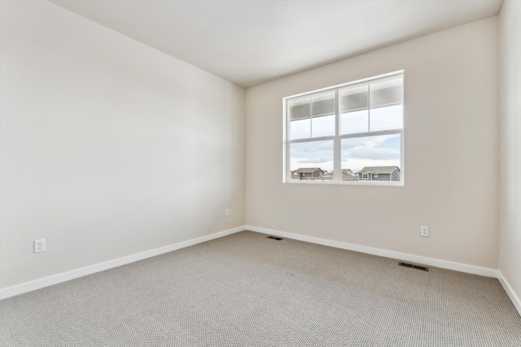 A room with a window and a carpet.