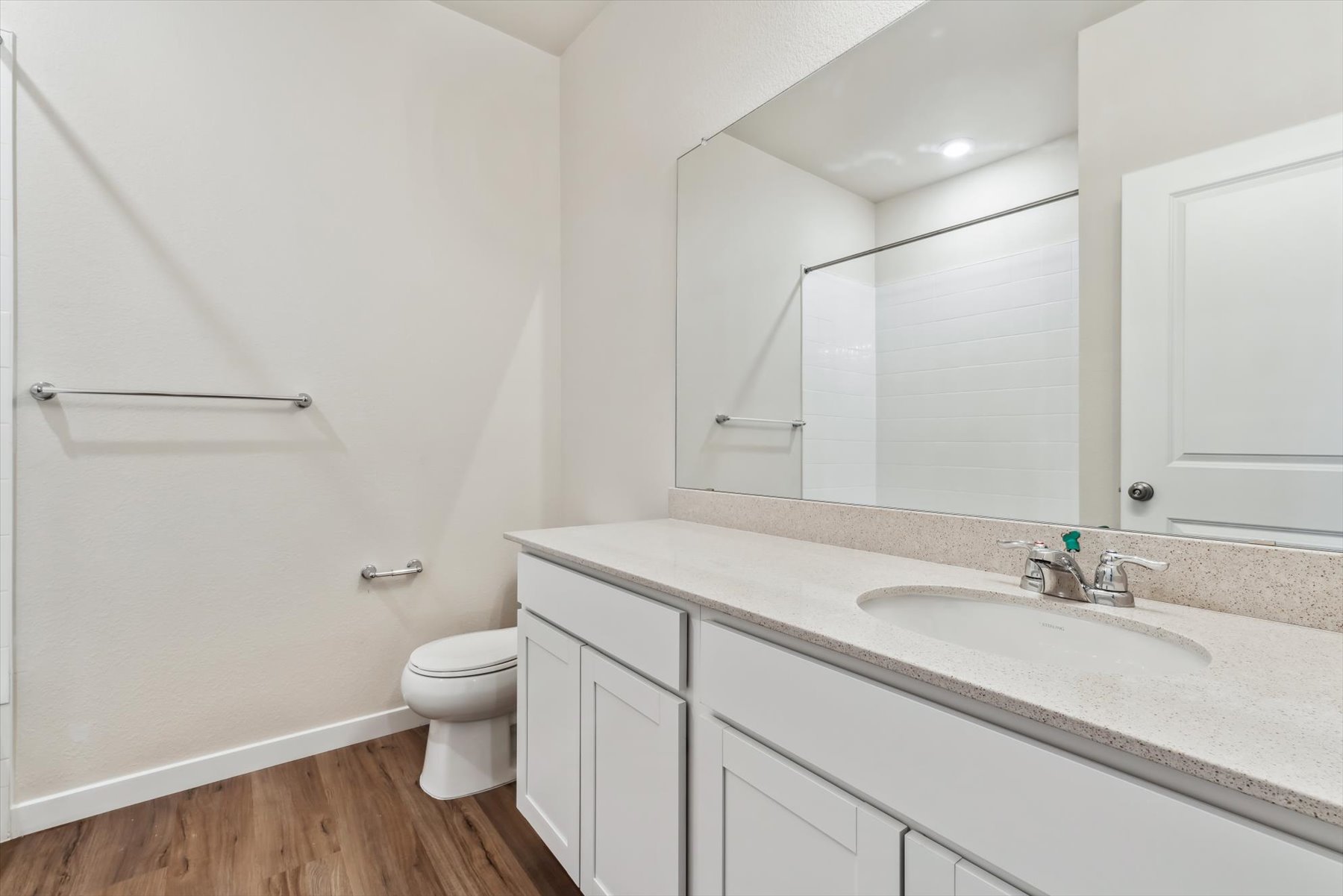 A bathroom with a sink toilet and mirror.