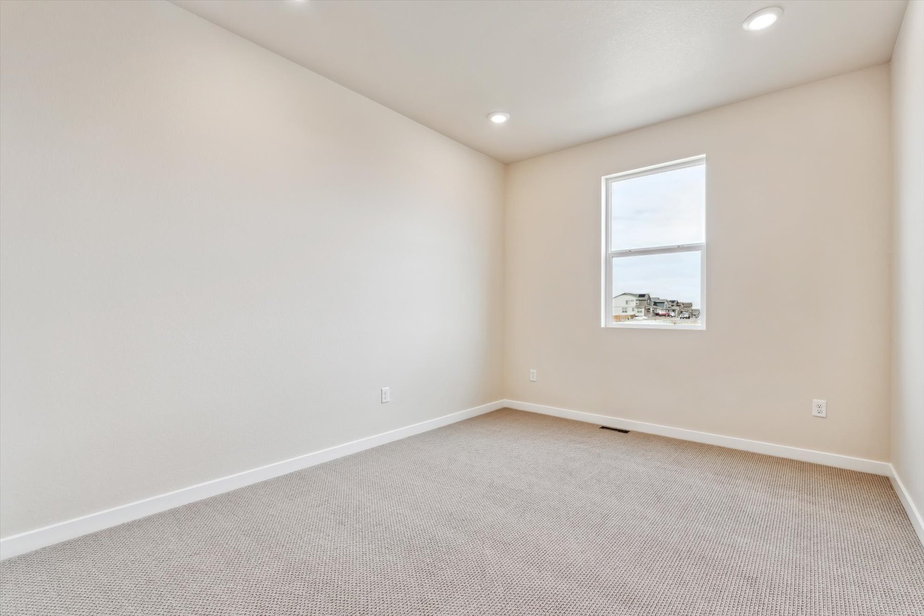 A room with a white wall and a window.