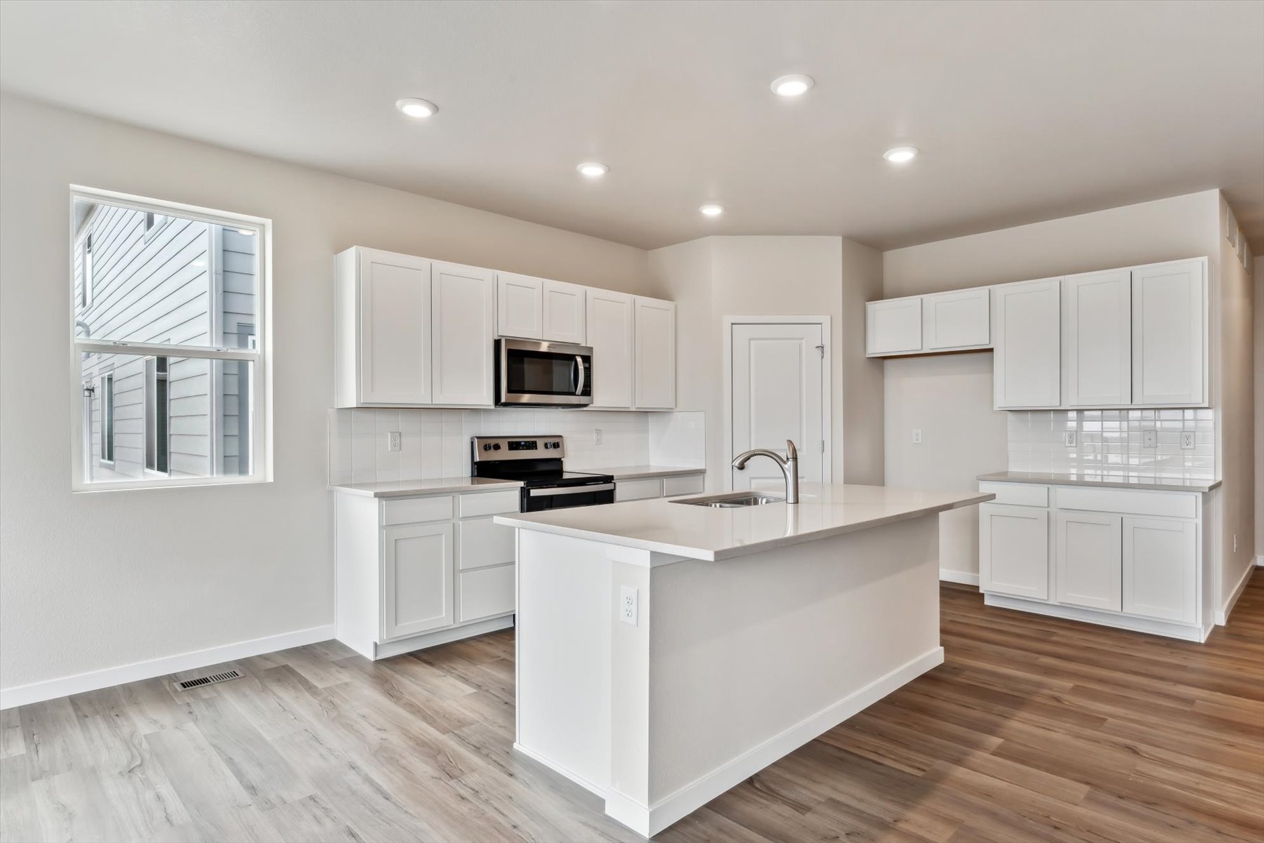 A kitchen with white cabinets.
