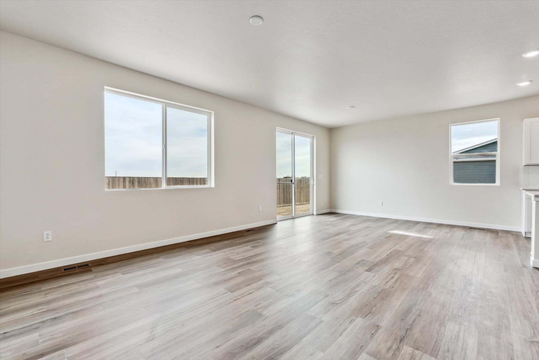 A room with a wood floor and windows.
