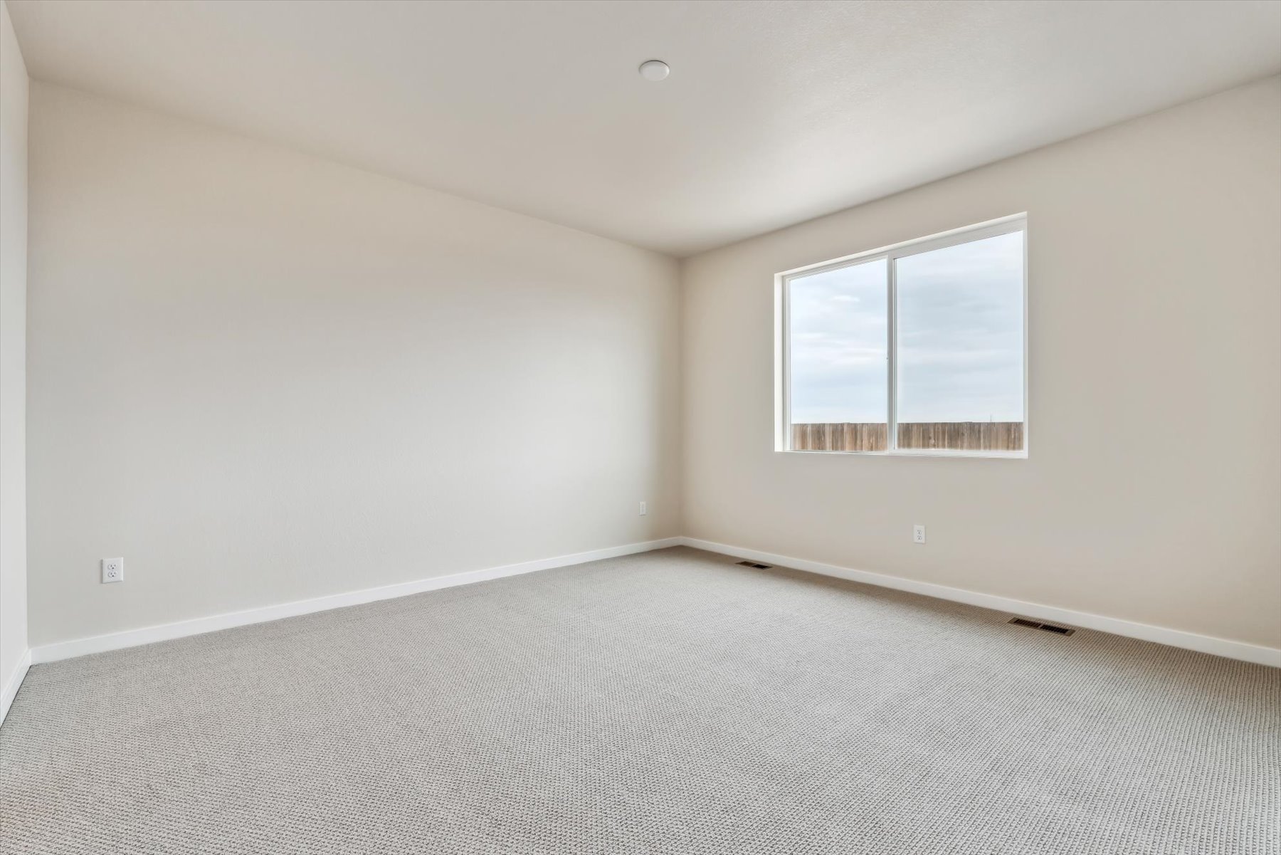 A room with a window and a carpet.