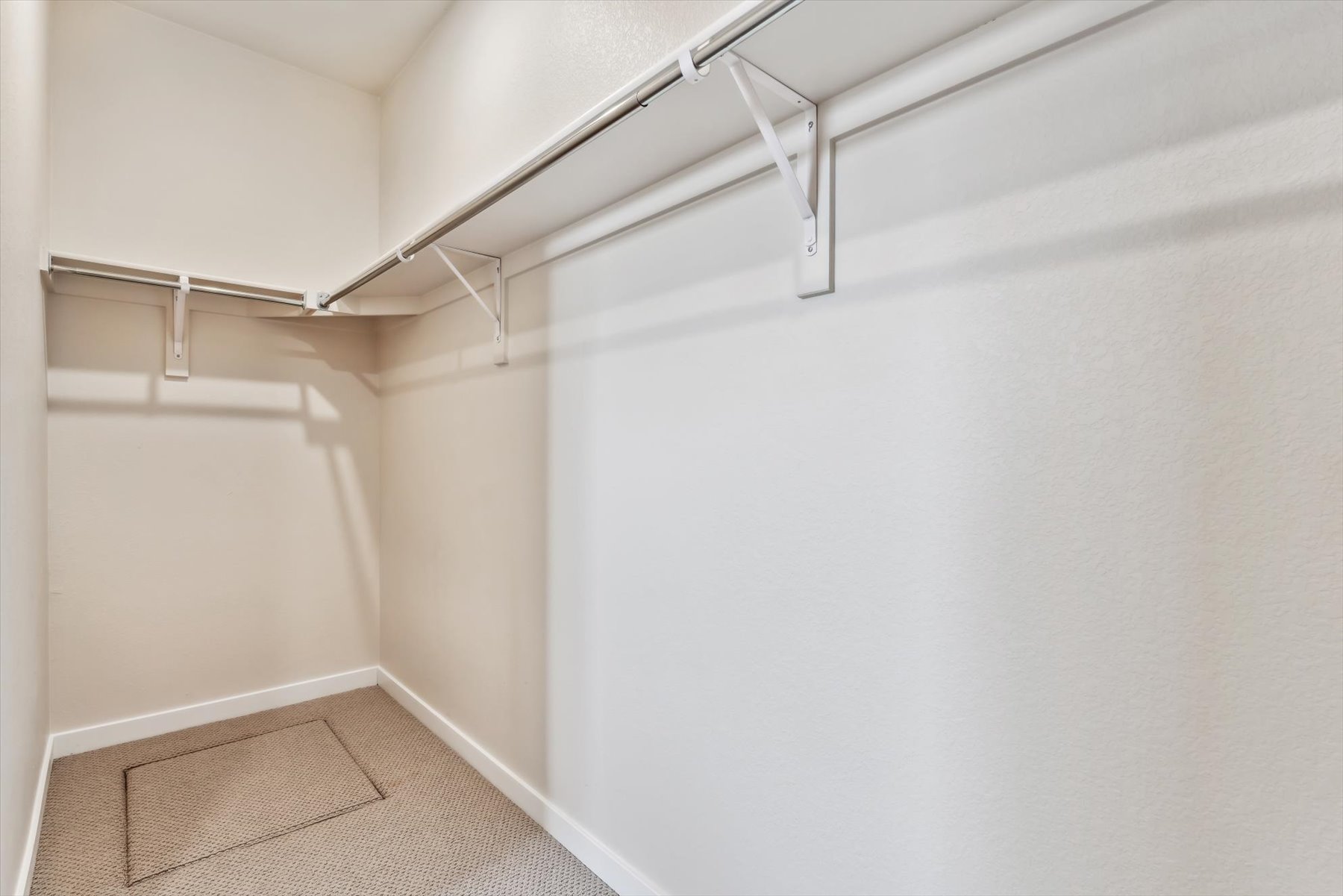 A white wall with a metal bar.