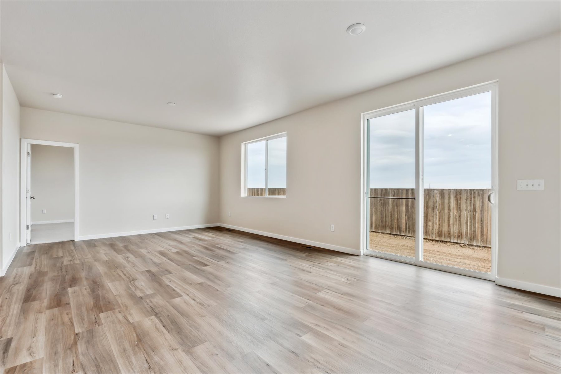 A room with a wood floor and a glass door.