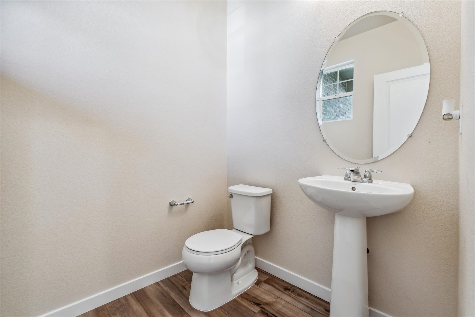A bathroom with a round mirror.