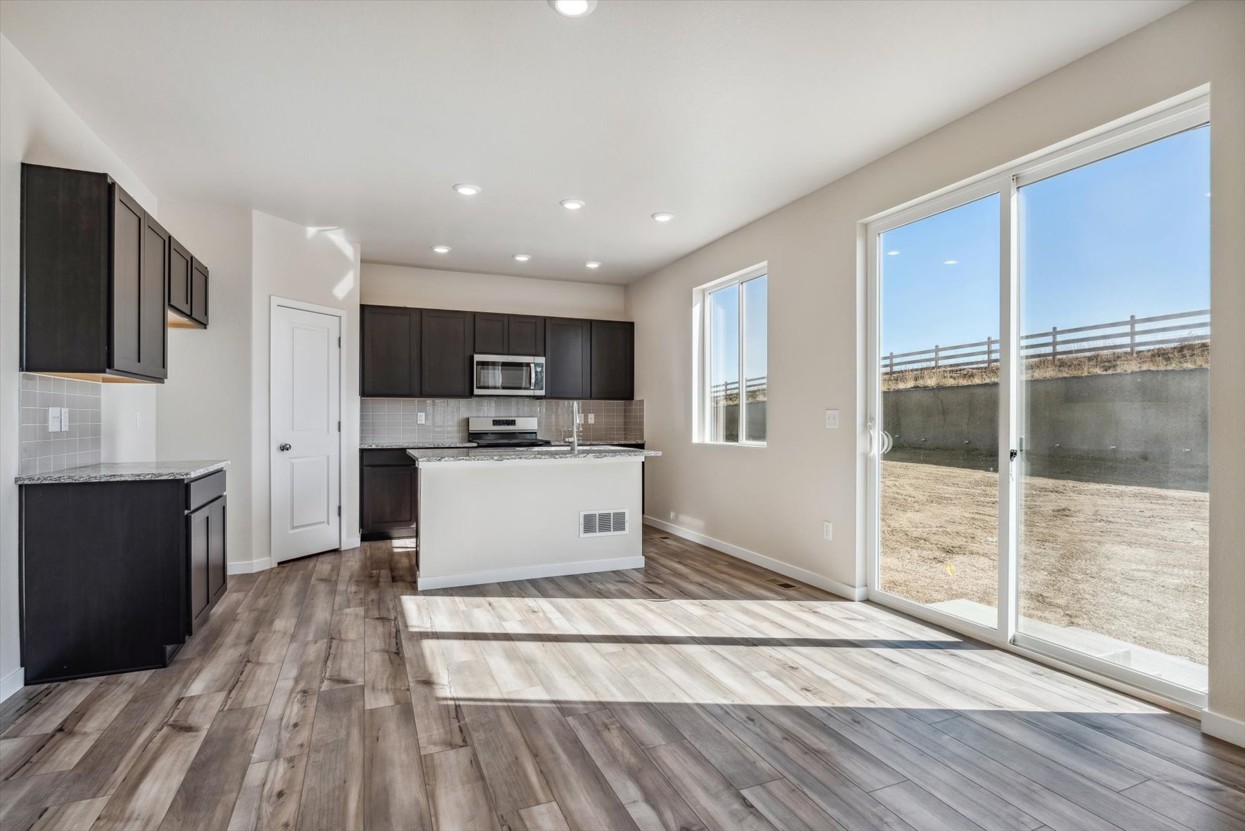 A large kitchen with a large glass door.