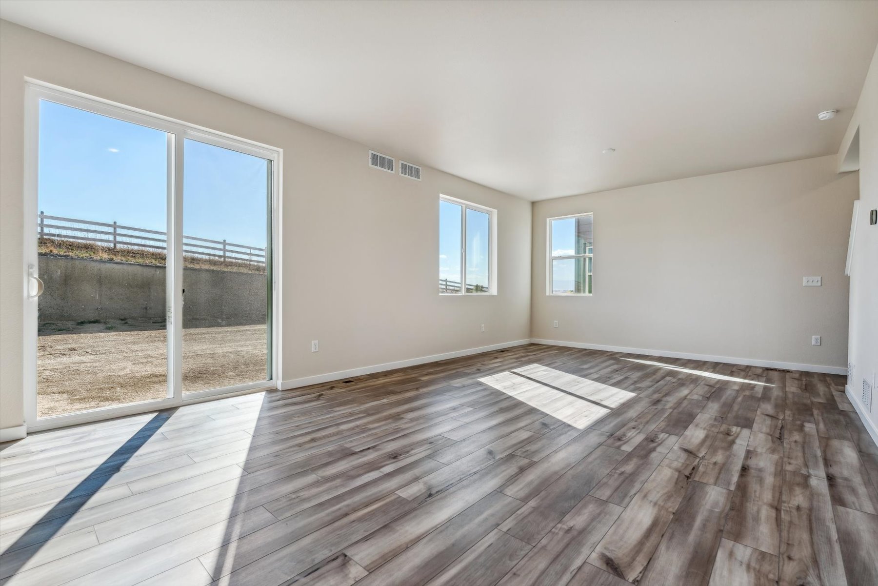 A room with a wood floor and windows.