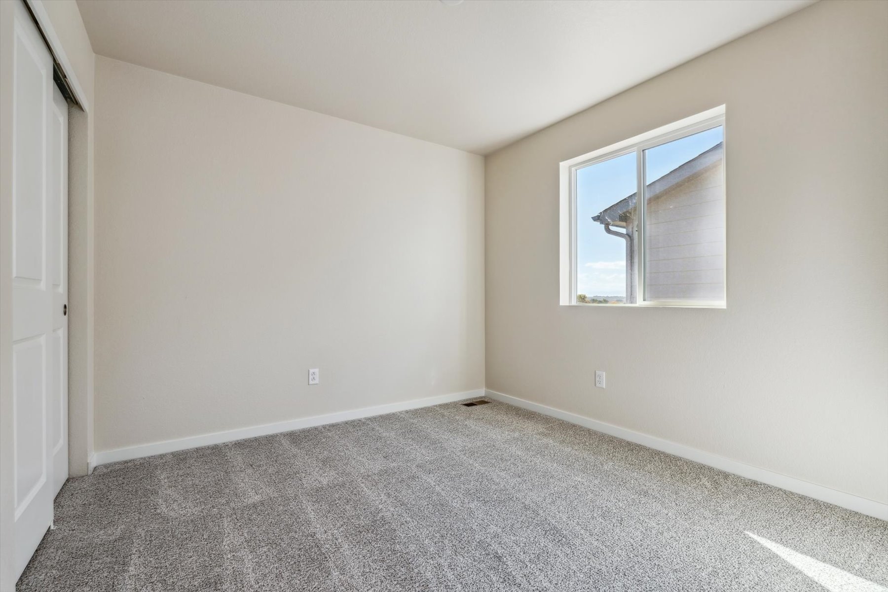 A room with a carpet and a window.