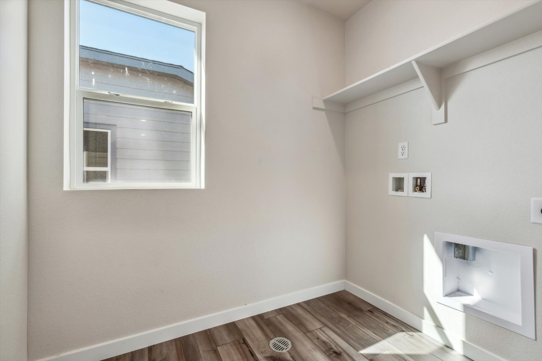 A room with a window and a wood floor.